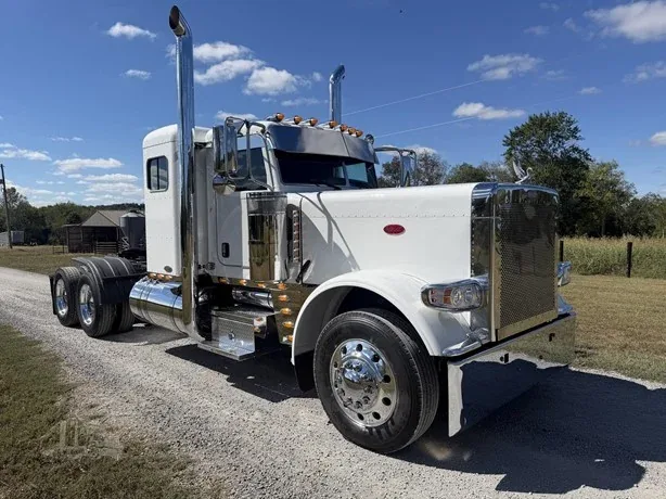 White semi truck parked on a gravel drive.